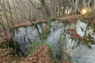 Low sun illuminates the rocks and caves of hell holes in the autumnal landscape of the Swabian Jura
