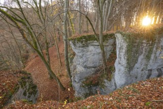 Low sun illuminates the rocks and caves of hell holes in the autumnal landscape of Dettingen an der