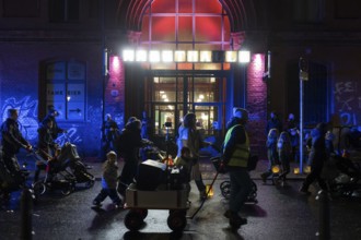 Participants with lanterns and strollers parade in front of the Arminiusmarkthalle during the