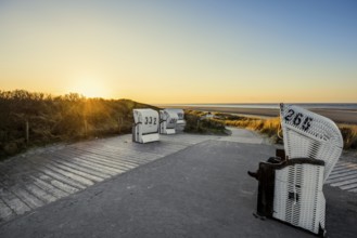 Beach chairs in the dunes and blue sky in winter, sunset, Spiekeroog, East Frisian Islands, Lower