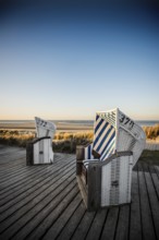 Beach chairs in the dunes and blue sky in winter, sunset, Spiekeroog, East Frisian Islands, Lower