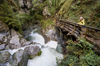 Female hiker standing on wooden walkway, Diosaz mountain river in the gorge, Gorges de la Diosaz,