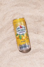 Carbonated lemonade with pear flavor, in an iron jar, Georgian drink, Borjomi, on a sandy beach,