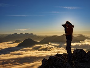 Photographer in evening light at the summit, view of an alpine panorama, Hochstaufen, Chiemgau