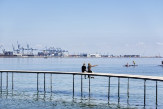 Two passers-by on circular bridge construction, wooden jetty, Infinite Bridge on Varna Beach,