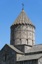 Detailed church tower with cross on top against a clear sky, main church Surb Pogos-Petros, Tatev