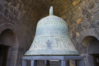 Ancient bell with engraved inscription in stone arch, church bell, Tatev monastery, Tatev, Armenian