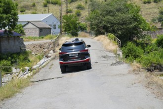 An SUV crosses a damaged bridge in a green, rural area, Toyota Fortuner on bridge over the Debed