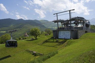 Cable car complex on green field against a background of mountains and cloudy sky, Tatev cable car,