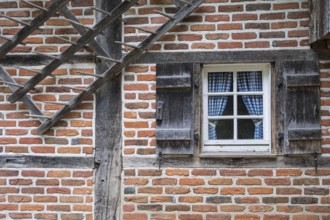 A rustic half-timbered house with red brick and wooden shutters, Münsterland, North