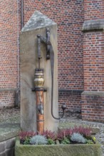 Old hand swing pump as decoration in front of a church, Vreden-Ammeloe, Münsterland, North
