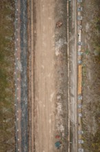 Vertical view of a construction site with earthworks and building materials along the route,