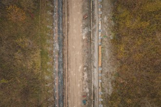 Aerial view of construction work on a road surrounded by autumnal nature, construction of the