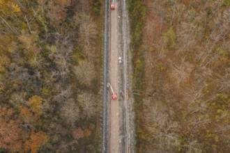 Aerial view of construction work along a slope in an autumn forest area, construction of the
