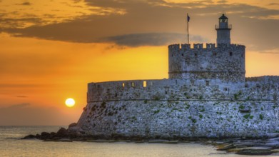 Agios Nikolaos fortress, castle with lighthouse in the golden hour at sunrise and peaceful sea in