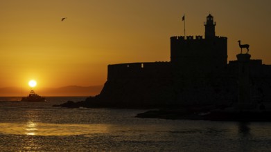 Agios Nikolaos fortress, sunrise over the sea with a castle silhouette and a passing boat, UNESCO
