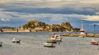View of an island with fortress and small boats in the water under cloudy sky, UNESCO World