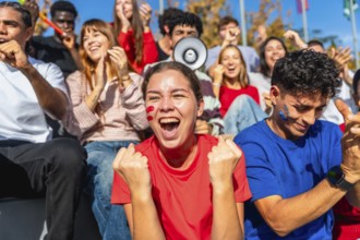 Young diverse fans sitting in a stadium enjoying a sporting event, celebrating and cheering for