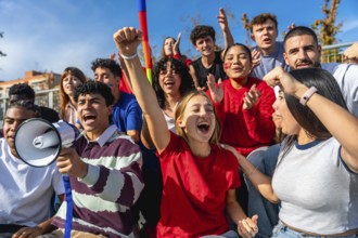 Group of diverse young activists raising fists and shouting at a daytime protest, united on campus