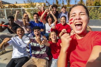 Group of diverse young sports fans cheering and celebrating success from the bleachers, sharing a