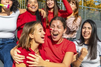 Group of excited diverse young women fans cheering loudly and celebrating a sports victory or game