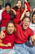 Diverse group of enthusiastic women celebrating and cheering for their favorite team at a sporting
