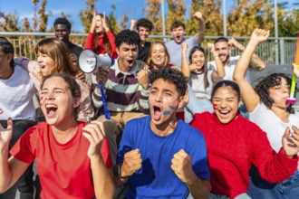 Energetic group of diverse young adults and friends showing excitement and support for their team,
