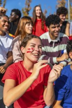 Young diverse friends and enthusiastic sports fans are cheering and clapping, showing excitement