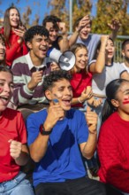 Young diverse fans intensely watching a sports game, cheering and celebrating together with face