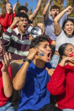 Young diverse people in a stadium are intensely cheering and shouting, supporting their team while