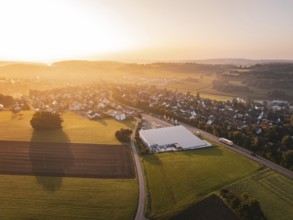 Aerial view of village with fields and sunset in the background, Gechingen, Germany