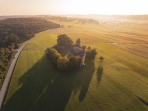 Rural area with farmhouse and fields in the evening sun from the air, Gechingen, Germany