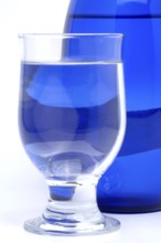 Glass with mineral water, small carbonated pearls on the edge of the glass, drinking water