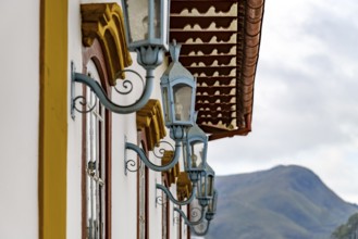 Several antique metal lanterns decorating the historical facade of a colonial-style house in the