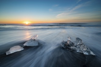 Beach with waves, ice formations, rising sun, Diamont Beach, Jökulsarlon, Iceland