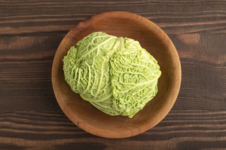 Green lettuce on plate on brown wooden background. Top view, copy space, flat lay. healthy food,