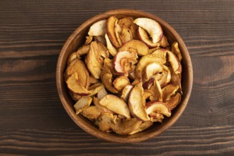 Dried Apples in wooden bowl on brown wooden background. Top view, close up, flat lay. healthy food,