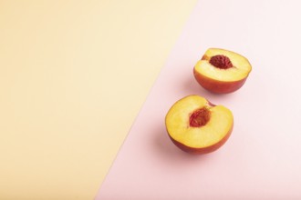 Peach Cut in half on orange and pink paper pastel background. Side view, copy space. healthy food,