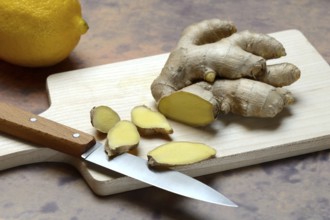 Ginger, ginger root cut with ginger slices on wooden boards