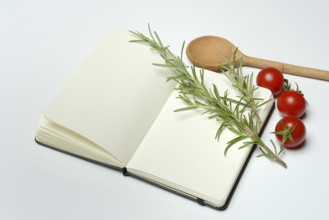 Blank notebook for cooking recipes, cooking spoon with rosemary sprig, tomato
