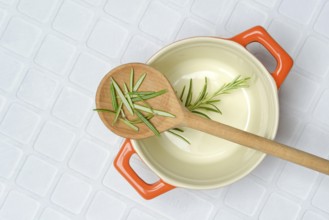 Rosemary, rosemary leaves on cooking spoon with cooking pot