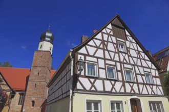 Half-timbered house and tower of the Catholic Church, town of Heideck in the district of Roth,