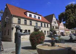 Half-timbered houses and fountain figure flute player, on Rathausplatz, city of Heideck in the