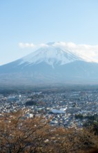 View of Mount Fuji volcano over Fujiyoshida City in the evening light, Yamanashi Prefecture, Japan