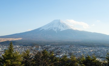 View of Mount Fuji volcano over Fujiyoshida City in the evening light, Yamanashi Prefecture, Japan