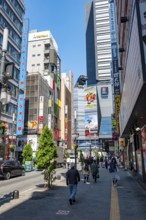 Street scene with skyscrapers, figure Godzilla head on a skyscraper, Shinjuku City, Tokyo, Japan