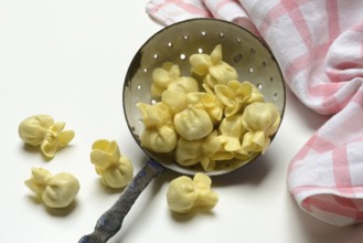 Saccottini, type of Italian pasta in a sieve ladle, pasta from Italy