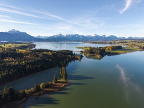 Clear reflections of a quiet lake surrounded by forests and mountains in autumn, Illasbergsee,