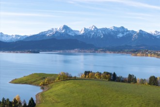 Harmonious alpine scenery with snow-capped mountain peaks, calm seas and autumnal vegetation