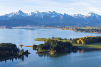 Clear lake with wooded islands against an impressive mountain backdrop, Illasbergsee, Forggensee,